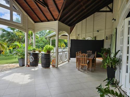 an outdoor patio with a table and chairs at Villa les Bougainvilliers in Rivière-Pilote