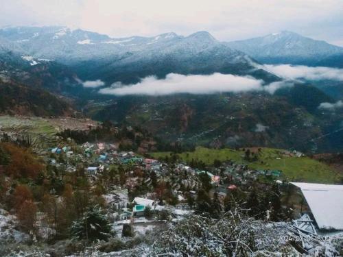 vistas a una ciudad en un valle con montañas en Ridhi Homestay Sari, en Ukhimath