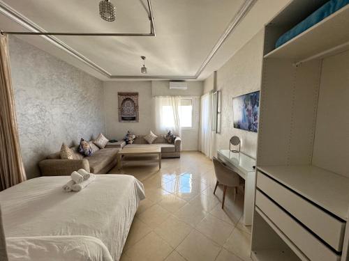 Studio Relax à Malabata Tanger في طنجة: غرفة نوم مع سرير وغرفة معيشة