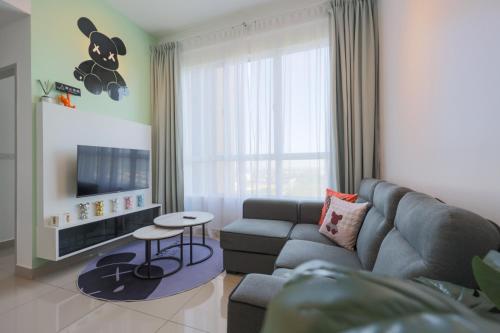 a living room with a couch and a tv at Bear Paw Retreat Cityview Apartment Amber Cove in Malacca