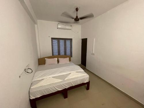 Dona Residency في نيدومباسيري: غرفة نوم بسرير ومروحة سقف