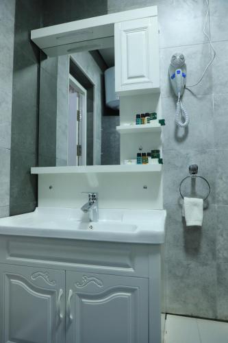a bathroom with a white sink and a mirror at HOBIZ Hotel in Navoi