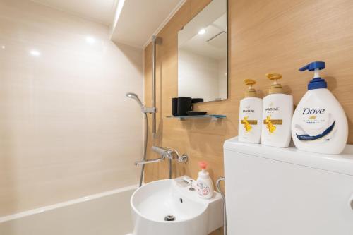 a bathroom with a sink and two bottles of soap at 心斎橋-道頓堀の宿 ー南海難波徒歩10分以内 in Osaka
