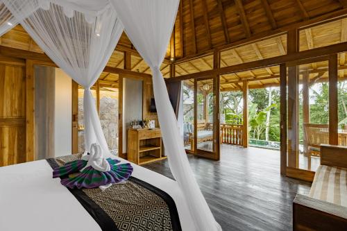 a bedroom with a bed with a mosquito net at Anandari Ubud Villa in Ubud