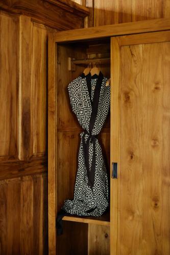 a black and white tie in a wooden cabinet at Anandari Ubud Villa in Ubud