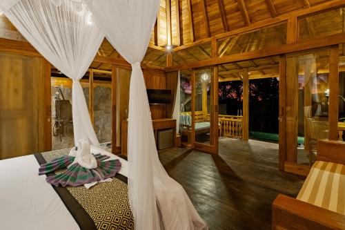 a bedroom with a bed with a mosquito net at Anandari Ubud Villa in Ubud