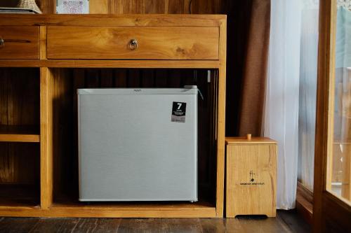 a small refrigerator sitting in a wooden cabinet at Anandari Ubud Villa in Ubud