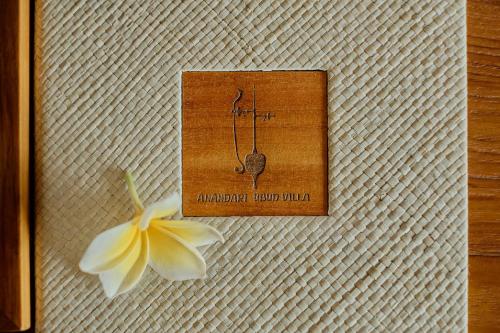 a flower is next to a card on a table at Anandari Ubud Villa in Ubud