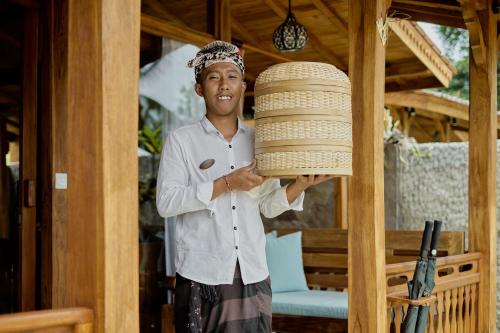 a man is holding a large stack of baskets at Anandari Ubud Villa in Ubud