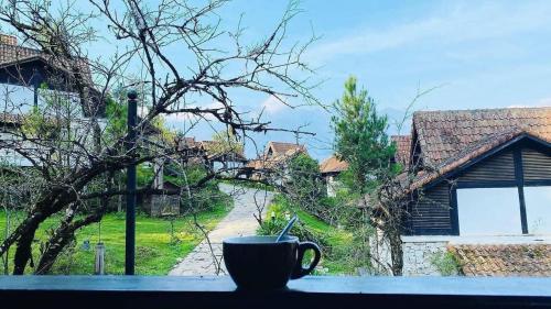 a coffee cup sitting on a window sill with a view at SAPA JADE HILL( CĂN CHỦ BIỆT THỰ) in Sa Pa