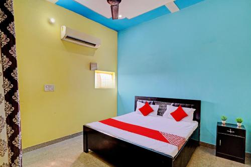 a bedroom with a bed with red and green walls at OYO Flagship Midtown Guesthouse in Jhājhar