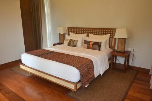 a bedroom with a large bed and two night stands at Pandan Villas, El Nido in El Nido