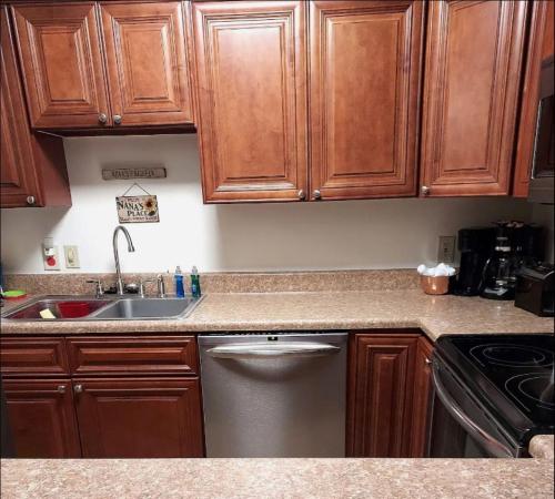 a kitchen with wooden cabinets and a sink and a dishwasher at Lovely 2 Bedroom Condo with Views of the Mountains in Gatlinburg