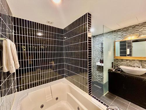 a bathroom with a bath tub and a sink at Ignis hotel in Yangsan
