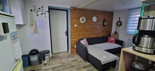 a living room with a couch and a wooden wall at Atelier d Antoine in Saasenheim
