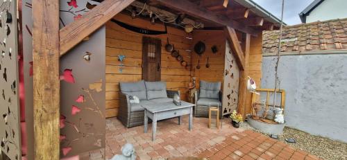 a house with two chairs and a table on a patio at Atelier d Antoine in Saasenheim