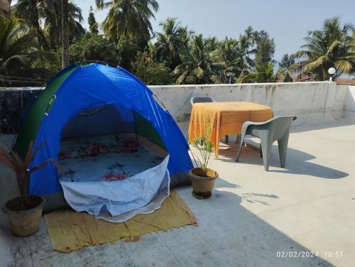 a blue tent on a patio with a table at Hotel Grand Murud janjira in Murud