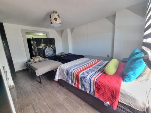 1 dormitorio con 1 cama con una manta colorida en Casa con alberca a 15min poliforum y centro max Brisas en León