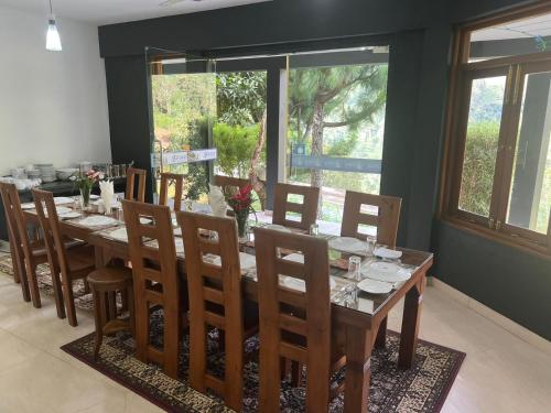 a dining room with a wooden table and chairs at Grace Holiday Bungalow in Haputale