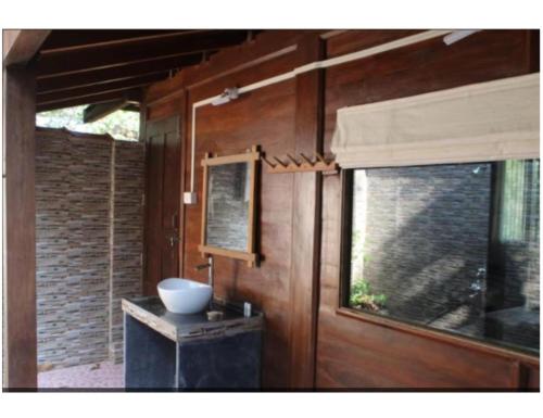 een badkamer met een kom op een aanrecht naast een raam bij Tanshikar Spice Farm, Sanguem in Vichondrem