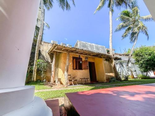 a house with palm trees in front of it at Hotel La Felicita in Mirissa