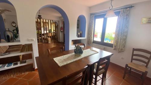 comedor con mesa, sillas y ventana en La casa de la abuela Maria en Almería