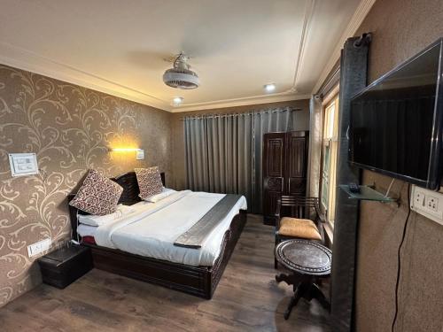 a bedroom with a bed and a flat screen tv at Lidder view resort in Pahalgām