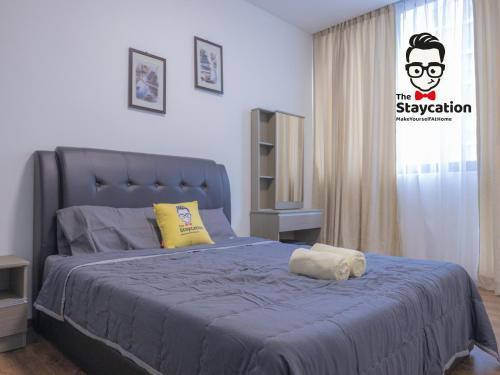 a bedroom with a bed with a blue comforter at Staycation Homestay 38 Viva J2 near Tabuan in Kuching