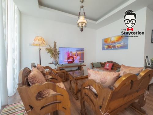 a living room with wooden chairs and a television at Staycation Homestay 38 Viva J2 near Tabuan in Kuching