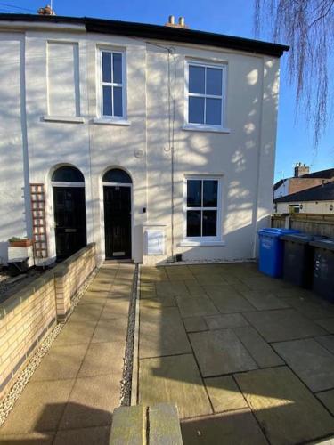 une grande maison blanche avec un trottoir devant elle dans l'établissement One bedroom apartment with garden., à Norwich