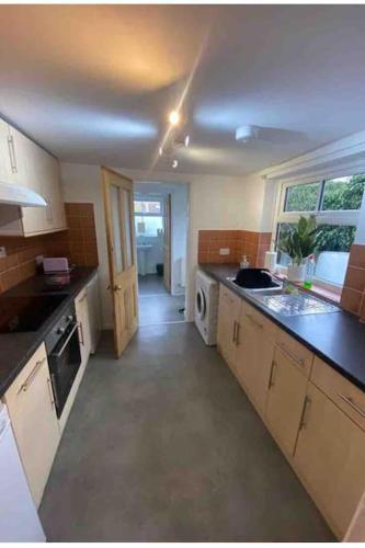 a kitchen with a sink and a dishwasher at One bedroom apartment with garden. in Norwich