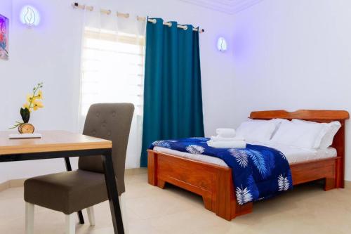 a bedroom with a bed and a desk and a table at House 5 Mins From the Beach, 15 Mins From the Airport in Cotonou