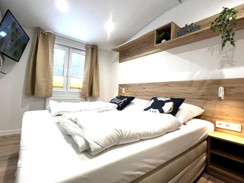 ein Schlafzimmer mit einem großen Bett mit weißer Bettwäsche in der Unterkunft Ostseecamp Ostseewind in Scharbeutz