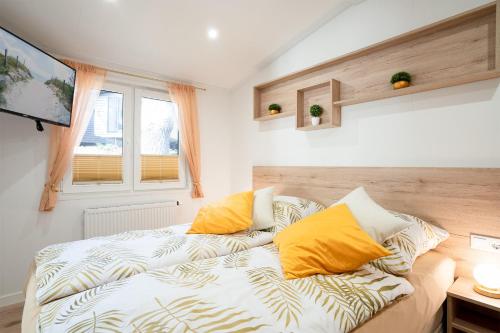 ein Zimmer mit einem Bett mit gelben Kissen darauf in der Unterkunft Ostseecamp Klabautermann in Scharbeutz