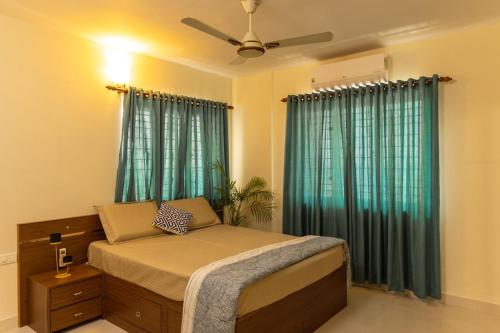 a bedroom with a bed with green curtains at BEST SERVICED APARTMENT IN COCHIN,MARINE DRIVE in Cochin