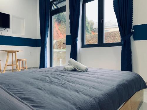 a bed in a room with a large window at November Villa Đà Lạt in Da Lat