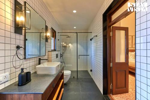 a bathroom with a sink and a toilet at StayVista's Villa Terra - Valley & Lake-View Villa with Spacious Lawn & Indoor Activities in Panchgani