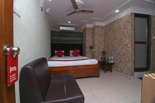 a bedroom with a bed with red pillows and a couch at OYO A G Residency & Son in Bumlitan