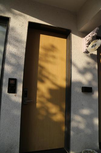a door with a shadow of a tree on a building at Suryaansh in Pālghar