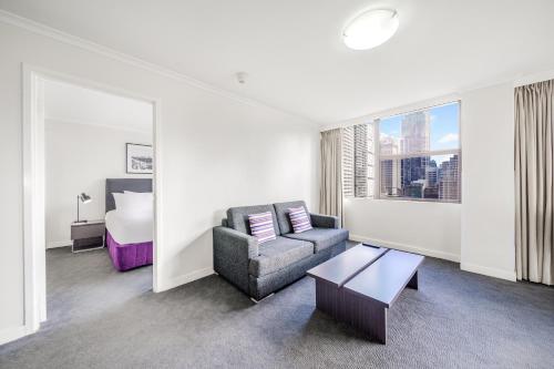 a living room with a couch and a bed at Oaks Sydney Hyde Park Suites in Sydney