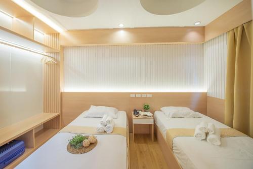 um quarto com duas camas com toalhas em Thrive Hotel em Banguecoque
