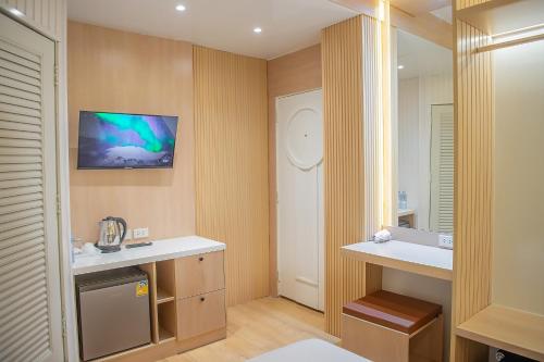 Thrive Hotel في بانكوك: حمام مع حوض وتلفزيون على الحائط