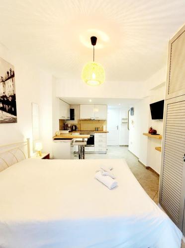 um quarto com uma cama branca e uma cozinha em Athens-acropolis apartment. em Atenas