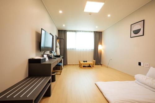 a living room with a couch and a tv in a room at Gangjin K-Stay Tourist Hotel in Gangjin