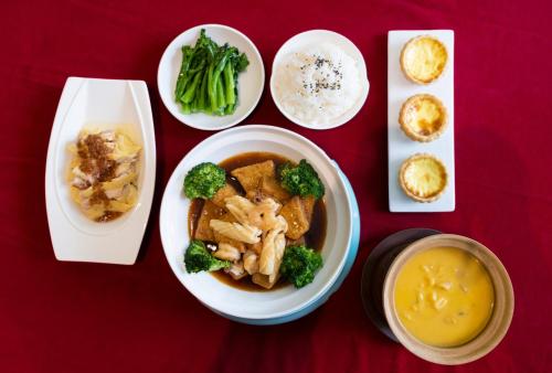 a table with a bowl of food with broccoli and other foods at Huaqiang Plaza Hotel Shenzhen, Enjoy Complimentary Mini Bar & Night Snack, Add breakfast - enjoy complimentary afternoon tea in Shenzhen