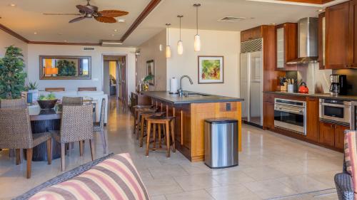 a kitchen and dining room with a table and a counter at Ko Olina Beach Villas O704 in Kapolei
