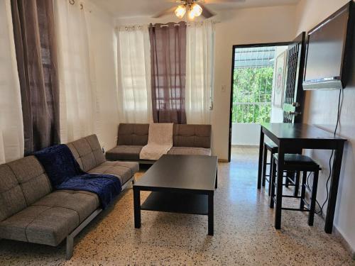 sala de estar con sofá y mesa en Newly remodeled 2nd Floor Unit, 5 BR, en Mayagüez