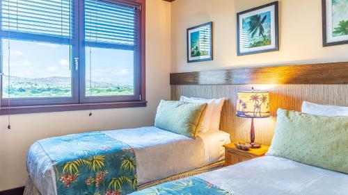um quarto com 2 camas e uma janela em Ko Olina Beach Villas O704 em Kapolei