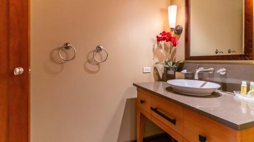 a bathroom with a sink and a mirror at Ko Olina Beach Villas O704 in Kapolei