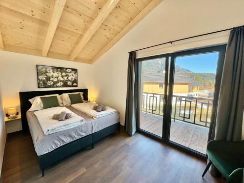 um quarto com uma cama e uma grande porta de vidro deslizante em Chalet near Lake Pressegger and Nassfeld ski area em Hermagor